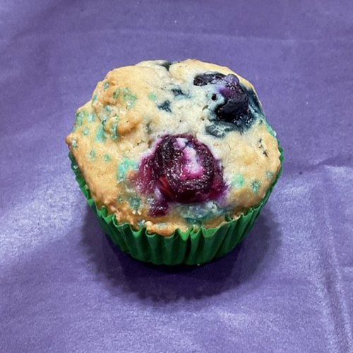 A muffin with blueberries on top of it.