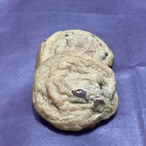 A close up of two cookies on top of purple paper.