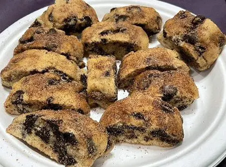 A white plate topped with lots of chocolate chip cookies.