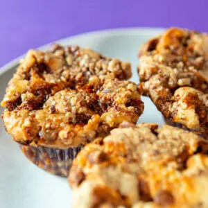 Three deliciously topped muffins on a plate.