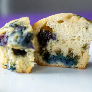 Cut muffin showing blueberries inside.