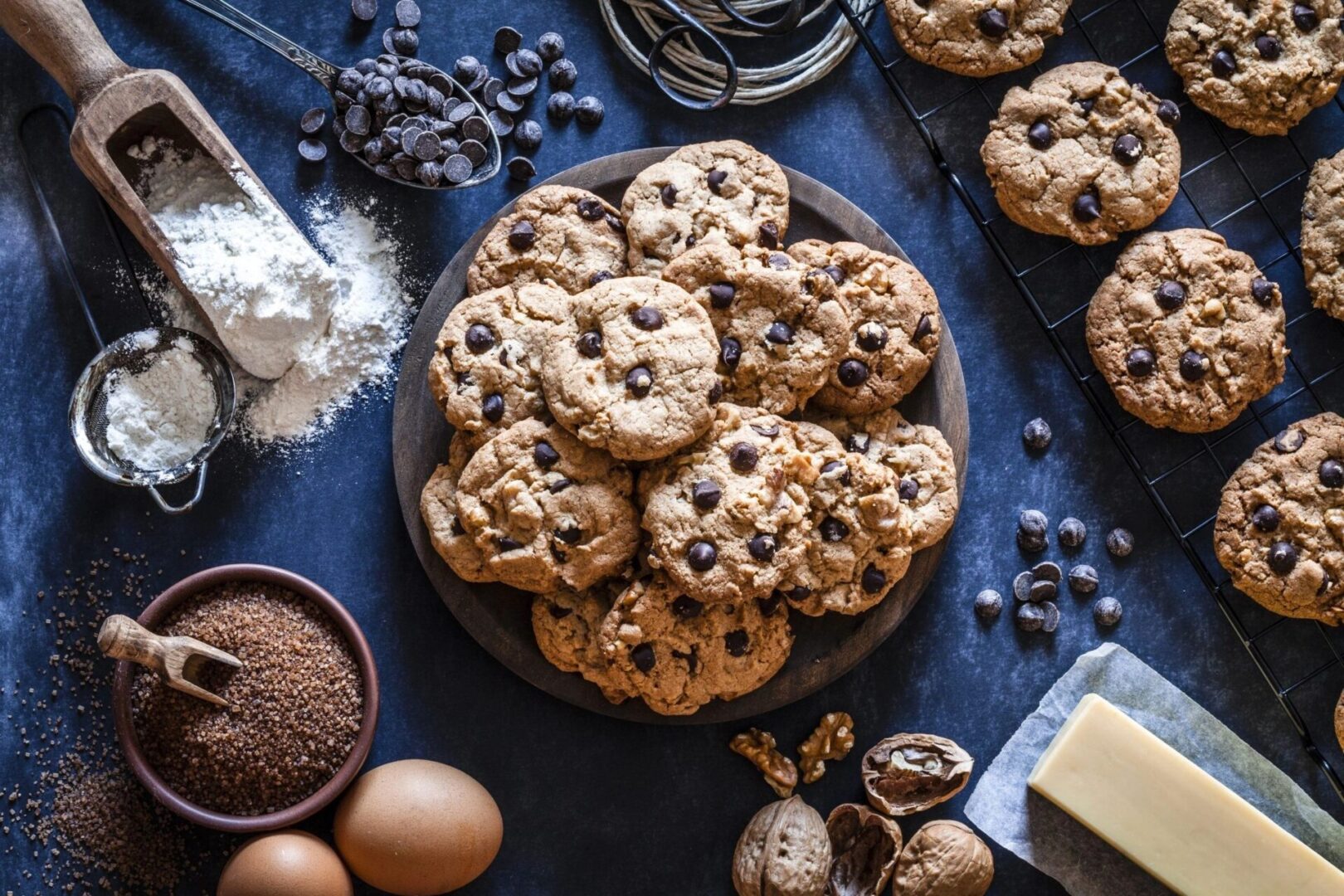 A plate of cookies on the table with other ingredients.