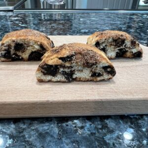 Three pieces of chocolate chip cookies on a cutting board.