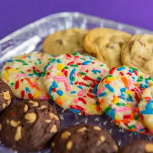 Colorful sprinkled cookies on a glass plate.
