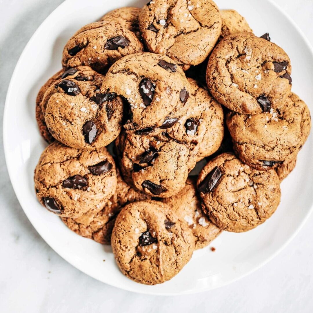 A white plate topped with chocolate chip cookies.